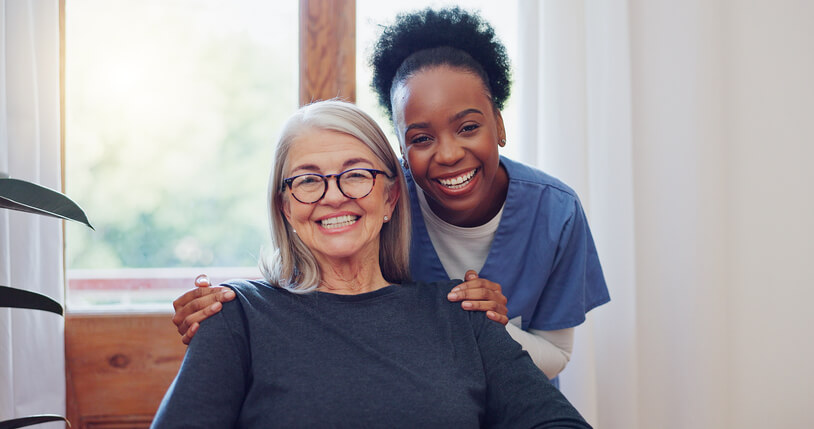 A smiling female community support worker with a smiling elderly patient