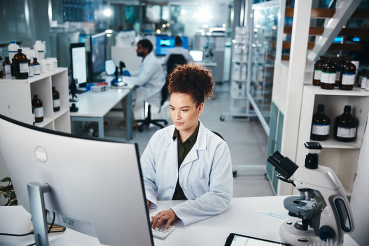 A focused female clinical research coordinator working in a laboratory