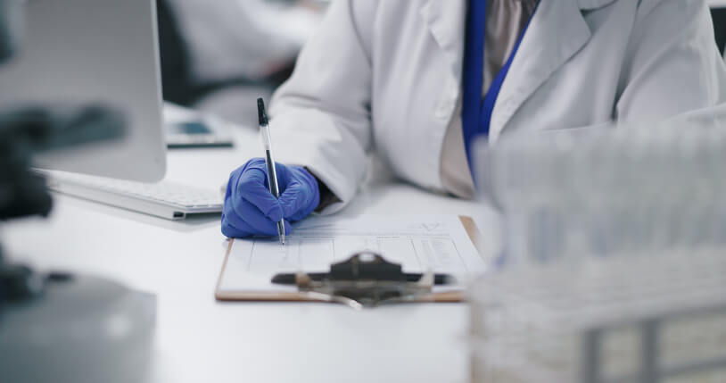 A clinical research coordinator completing a checklist in a lab