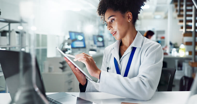 A clinical research coordinator working on a tablet in a lab