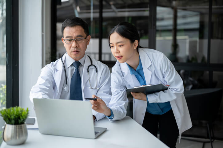 A clinical research coordinator showing notes to her supervisor