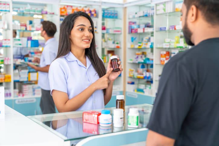 A pharmacy assistant helping a customer at the counter