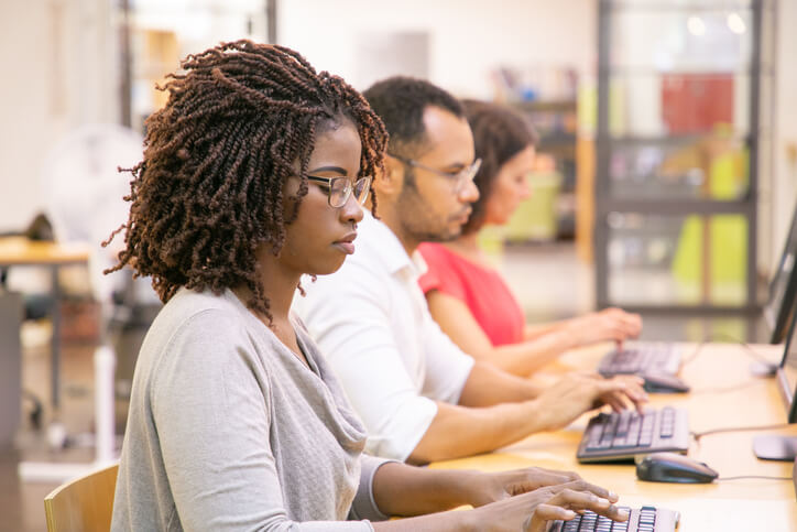 A row of career college students working on an online project
