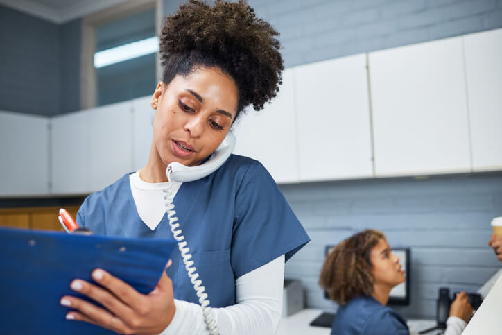A medical office administrator working at a front desk