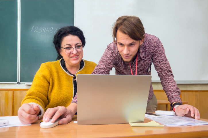 Educational assistant collaborating with a teacher to support learning in a Canadian school
