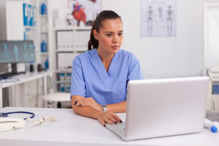 A pharmacy assistant using computer software to process prescriptions