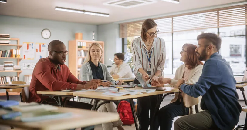 A Teacher and two education assistants collaborating in a classroom