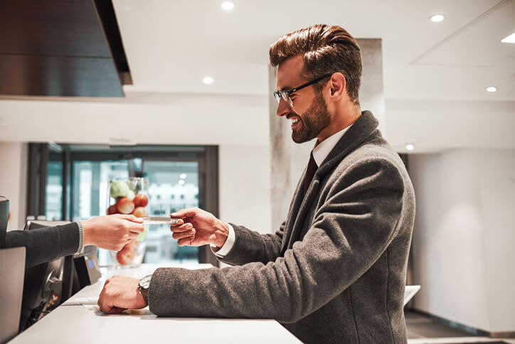 A hospitality professional greeting guests at a luxury front desk