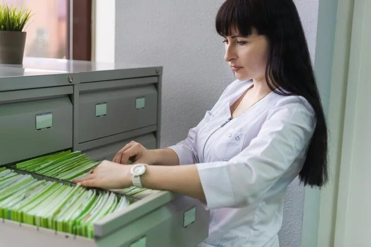 A medical office administrator organizing patient files