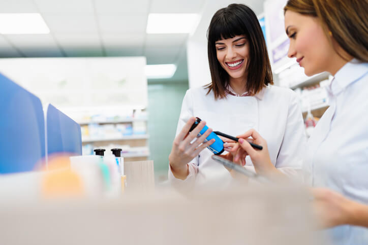 A pharmacy assistant helping a pharmacist fill prescriptions