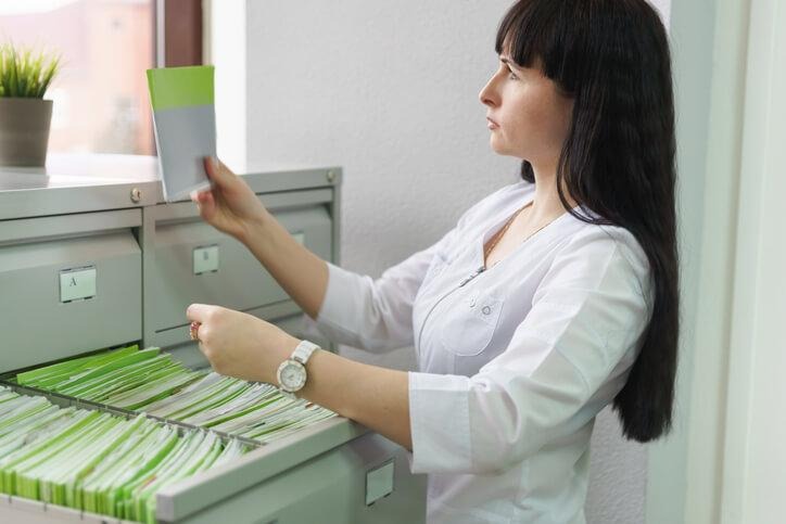 Medical office assistant vs unit clerk: medical office assistant managing patient files at a clinic