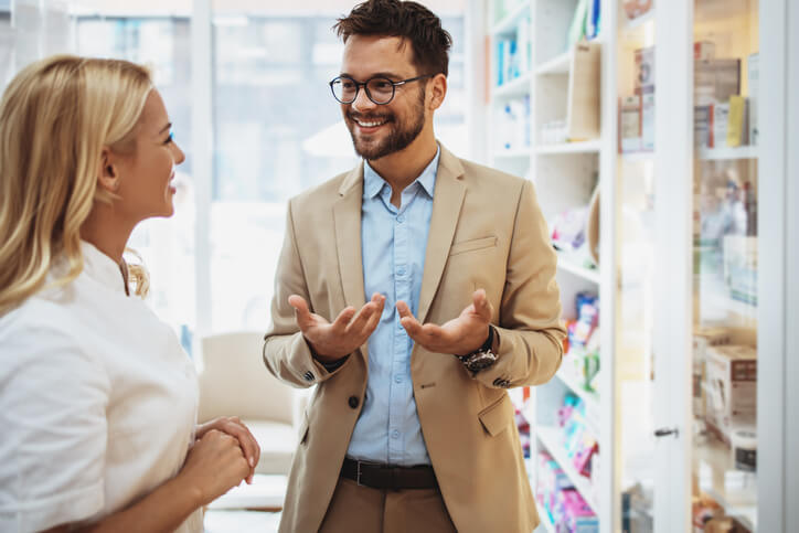 An interview candidate confidently speaking with a hiring manager in a pharmacy
