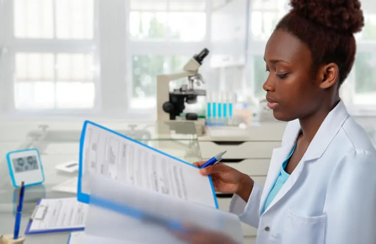 A clinical research assistant working with trial documentation, demonstrating a step in the clinical research career path