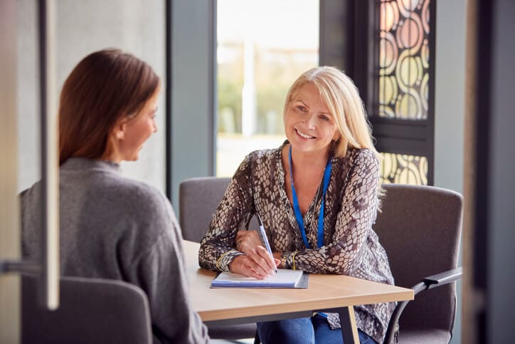 A community support worker providing guidance and emotional support during a client meeting