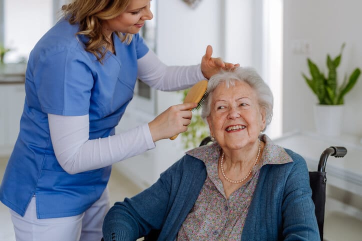 A personal support worker helping an elderly patient with daily care at home