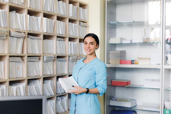 A medical office administrator organizing patient records in a clinic