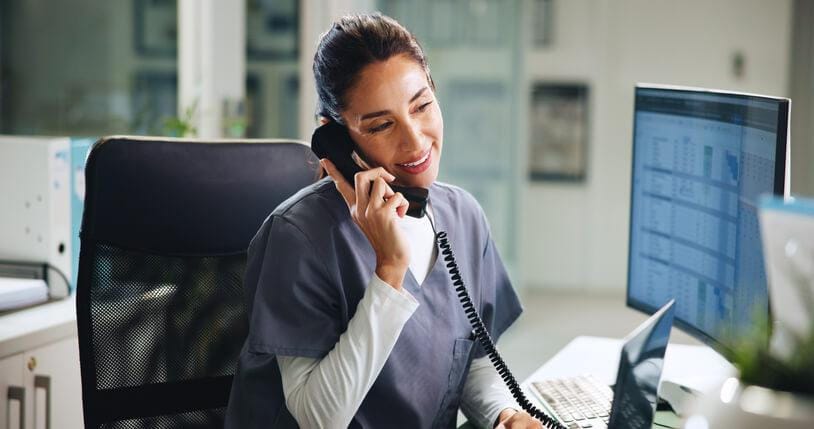 A medical office administrator scheduling patient appointments on a computer