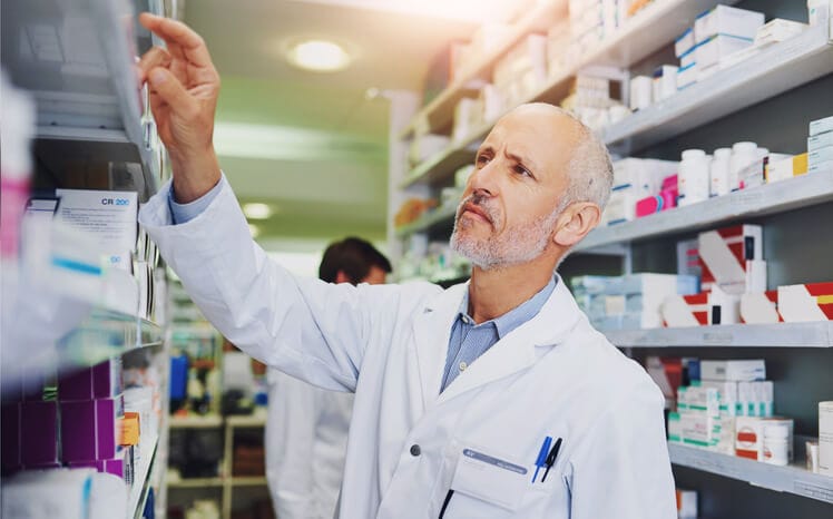 A pharmacy staff member is organizing prescription medications in a hospital pharmacy