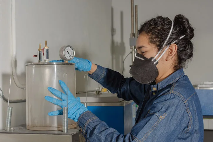 An environmental technology student using environmental testing equipment during lab training