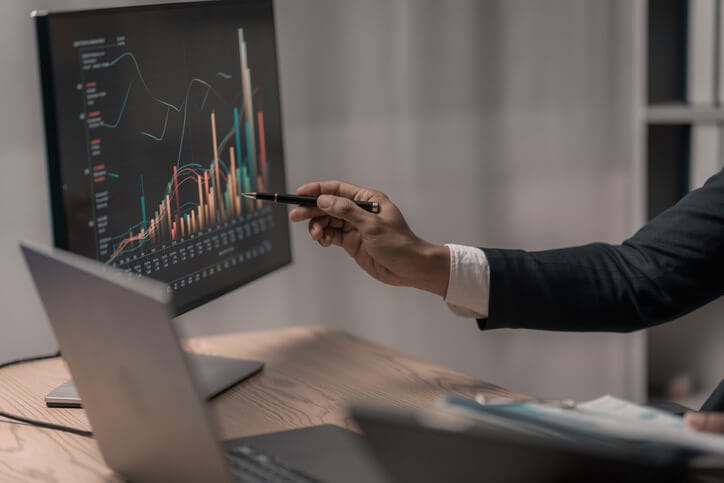 A business manager reviewing international market data and trade reports in a corporate office