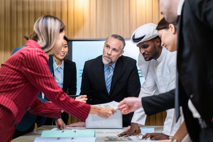 A diverse international business team discussing cross-border operations and global markets