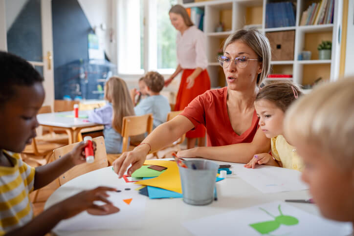 A group of students learning in an inclusive classroom with an education assistant's support