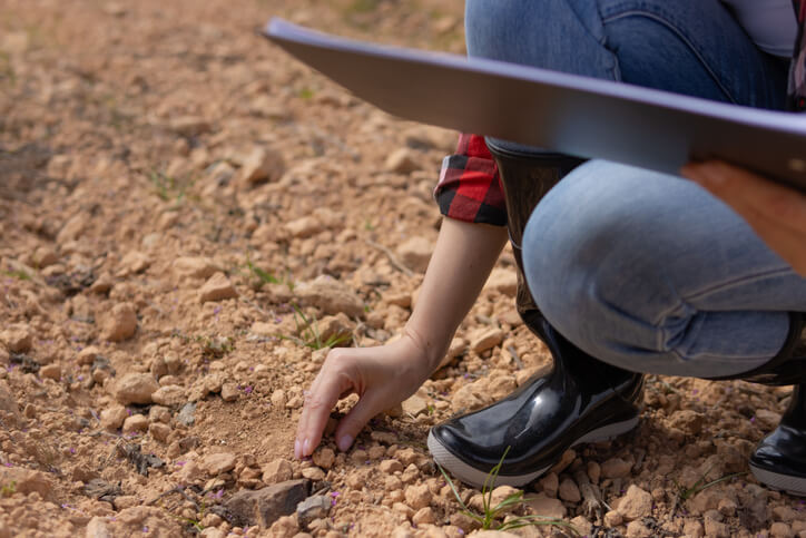 An environmental technology student conducting field sampling during an environmental site assessment