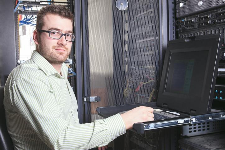 Network administrator student configuring computer networking equipment