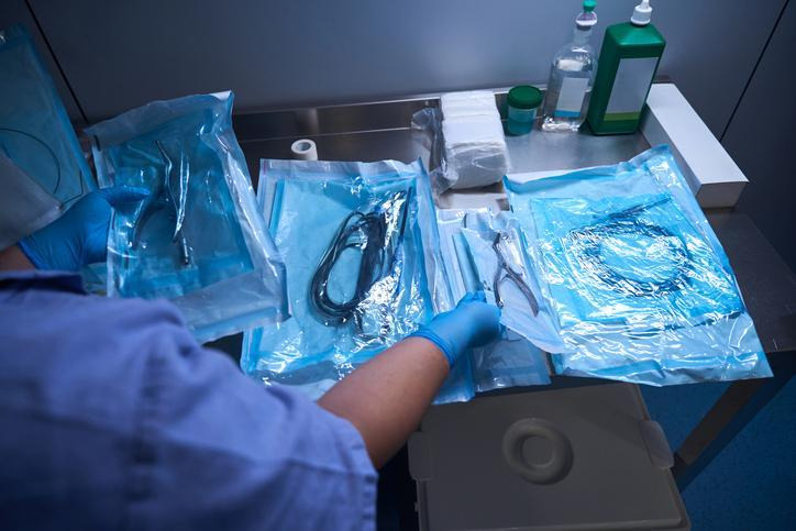 A sterile processing technician packaging surgical instruments for storage